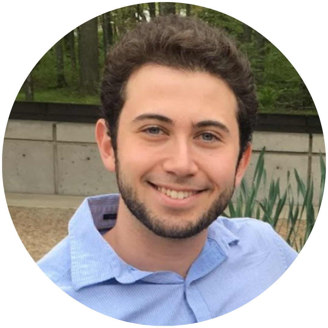 headshot of Joshua Berman, a white man with brown hair, smiling at the camera, wearing a blue shirt, outside