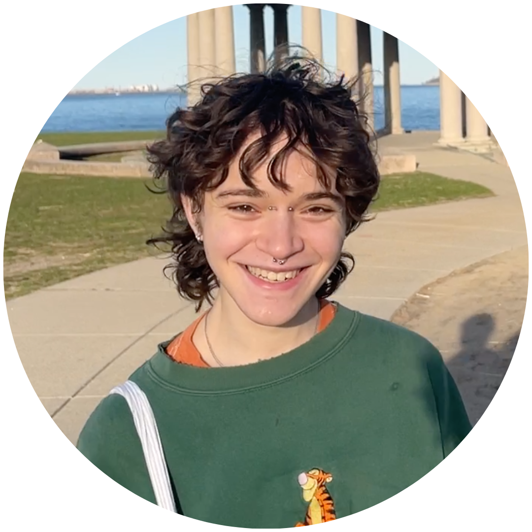 a person with brown hair smiling at the camera wearing green